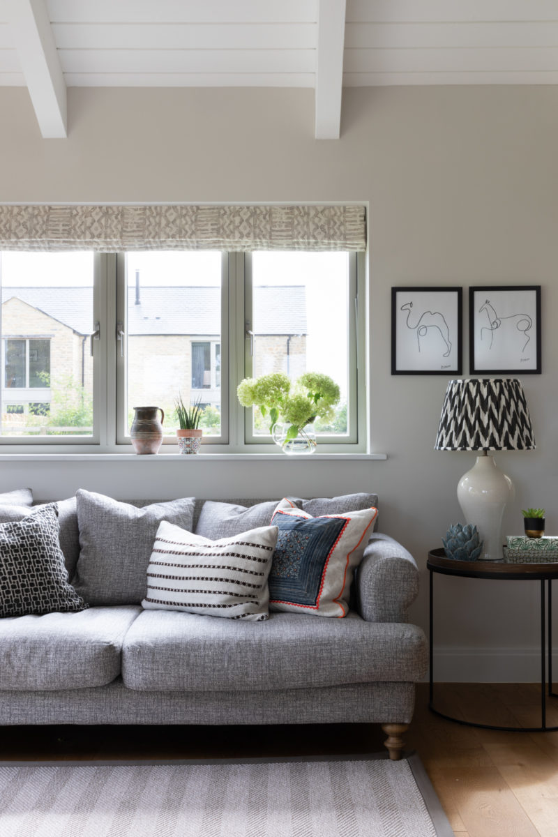 Cushions on sofa in blue, grey and black with table lamp & ikat shade on side table