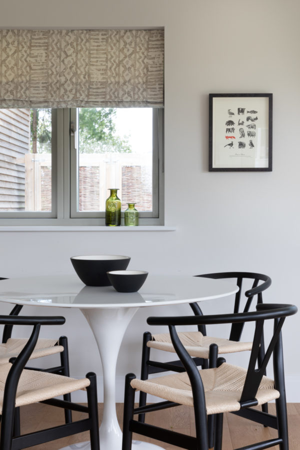 modern kitchen with round tulip table and black Hans Wegner chairs