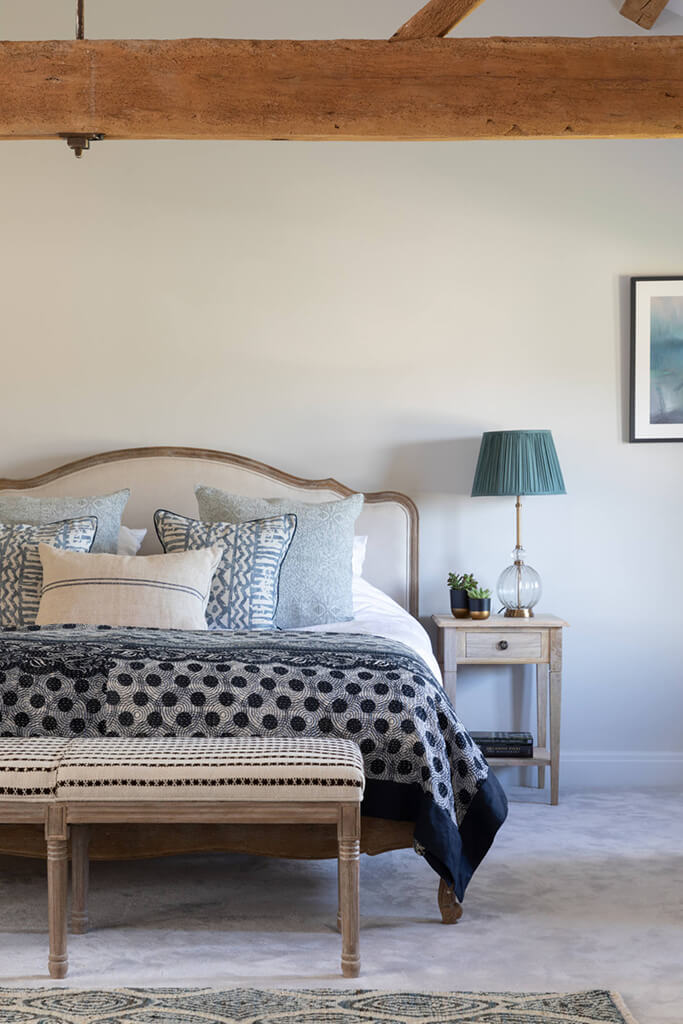 Master bedroom with wood beams, natural textures and colours and blues; grey walls