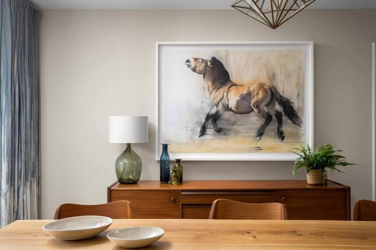 Painting of horse over sideboard in mid-century dining room