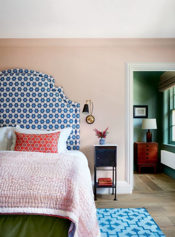 bedroom with blue headboard and soft textures of pink and lilac