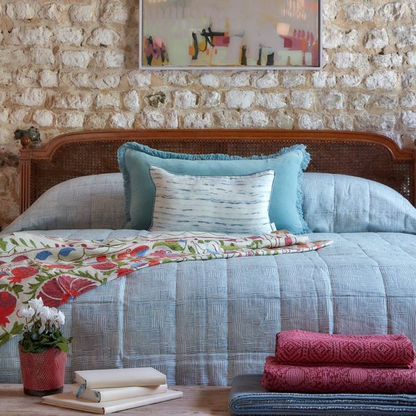 bedroom with stone wall and pretty shades of blue and pink