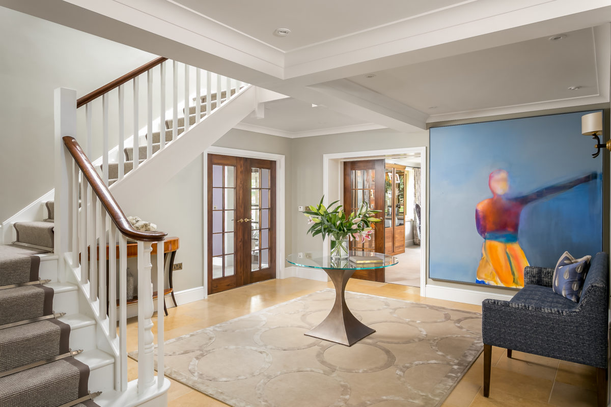 Rug in entrance hall with curved staircase and round pedestal table