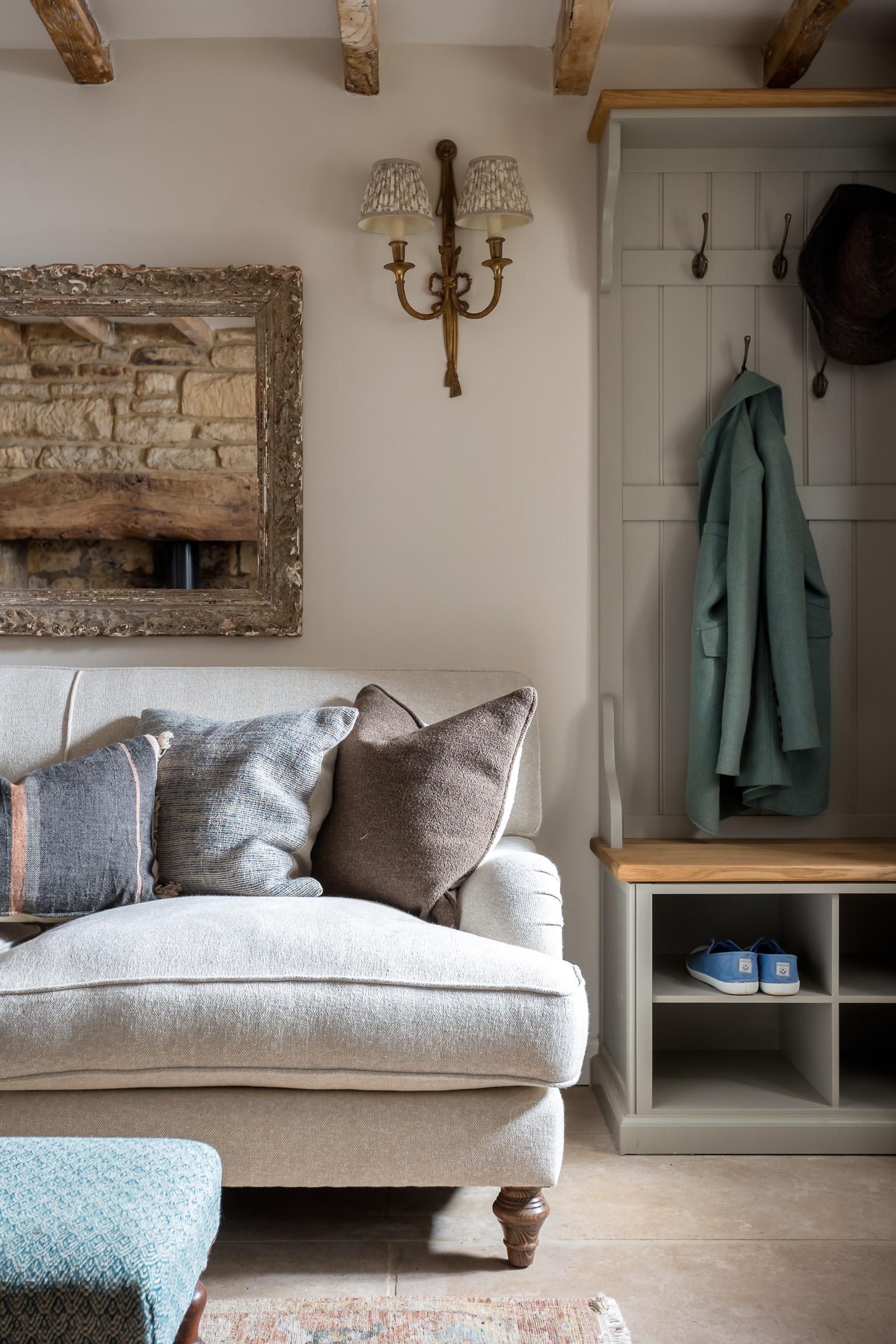 Cosy sofa, antique mirror and wall lights. Built in coat rack