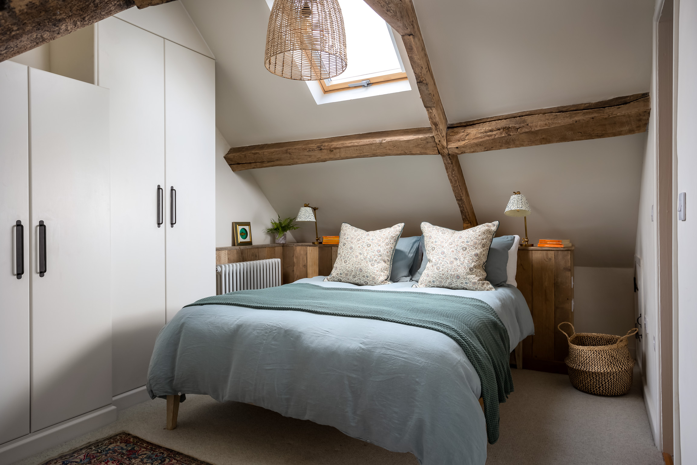 Attic bedroom with built in cabinetry and beamed ceilings