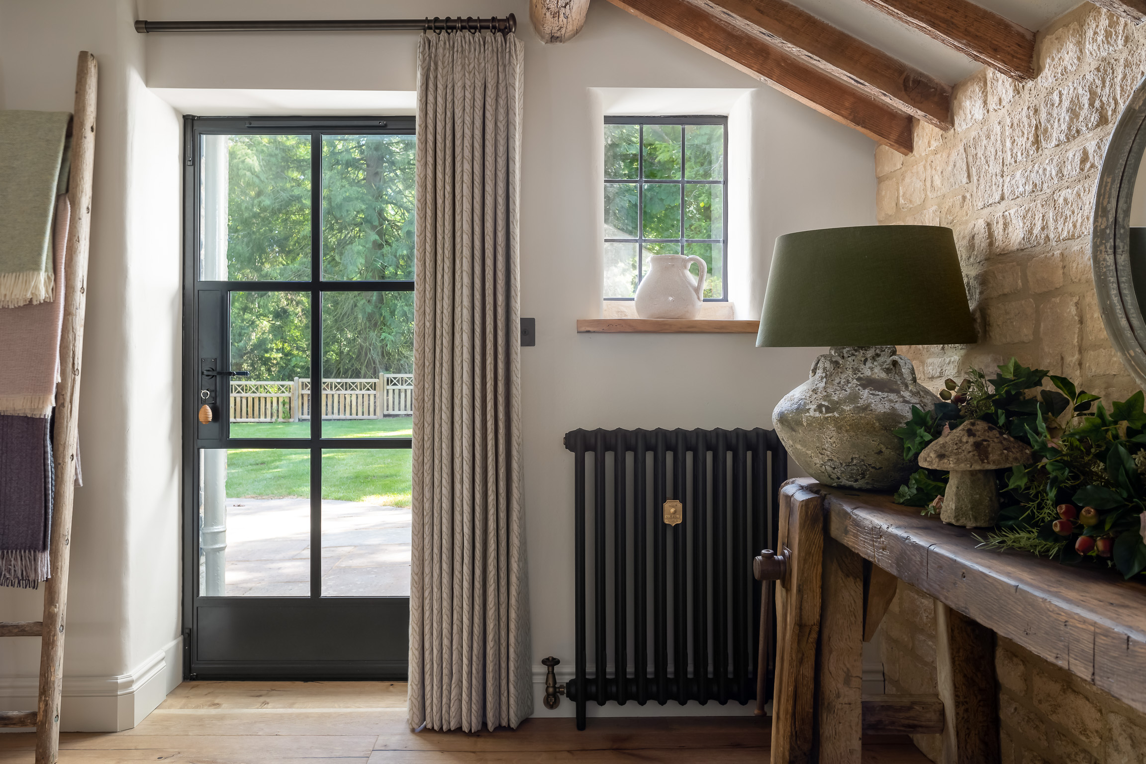 Crittal door to garden, curtains, traditional column radiators. Vintage wood console, concrete lamp