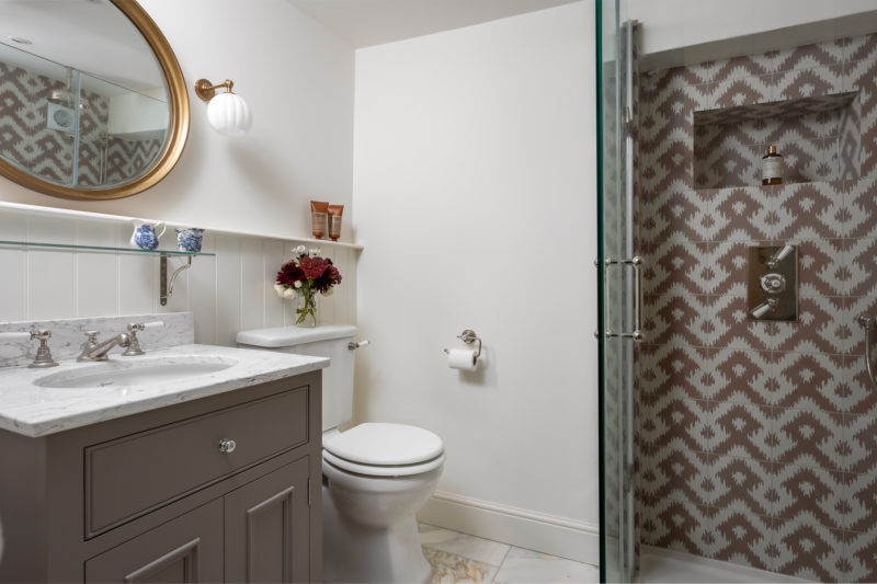 Shower room with nickel fittings, pink ikat wall tiles & marble floor tiles