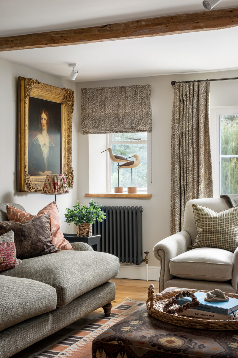 Living room with 2.5 seat sofa in olive green, large armchair, old master painting, green vine linen curtains