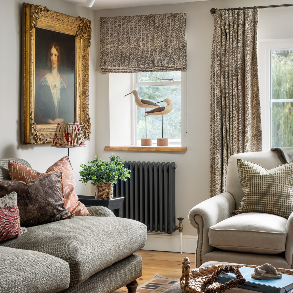 Living room with 2.5 seat sofa in olive green, large armchair, old master painting, green vine linen curtains