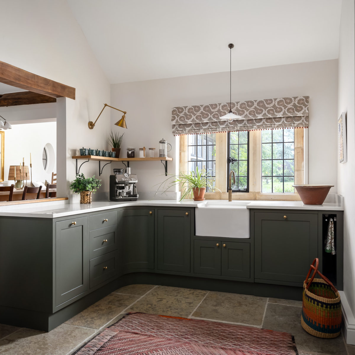 Shaker kitchen in dark olive green. Cotswold stone floor, antique rug, quoter tap